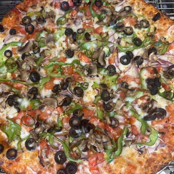 Mighty Munch Mtn Curry Pizza with green peppers, mushrooms, black olives, and tomatoes.
